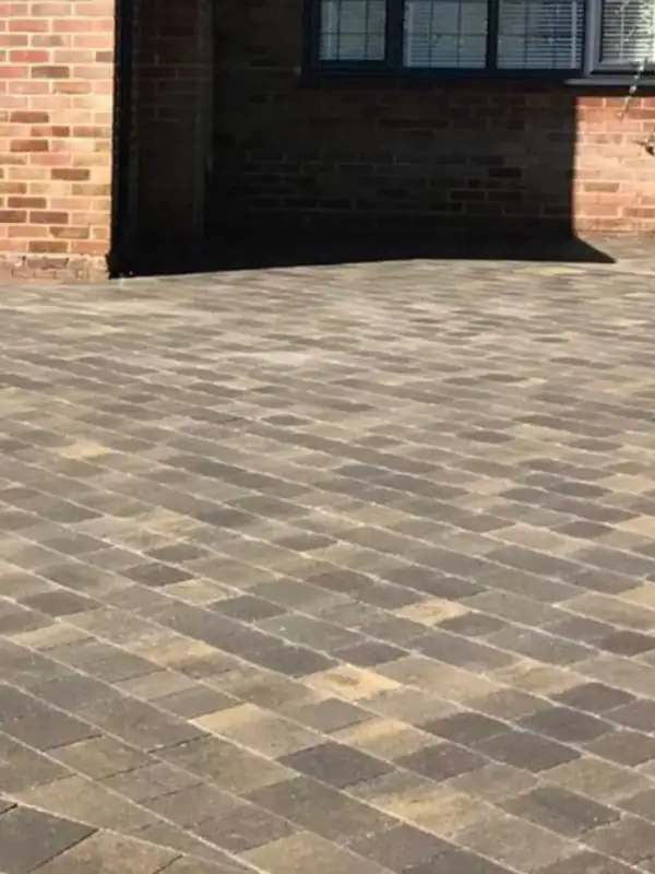 Block paved driveway with a contrasting border at a brick house