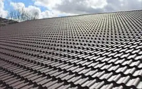 Clean dark tiled roof against the sky